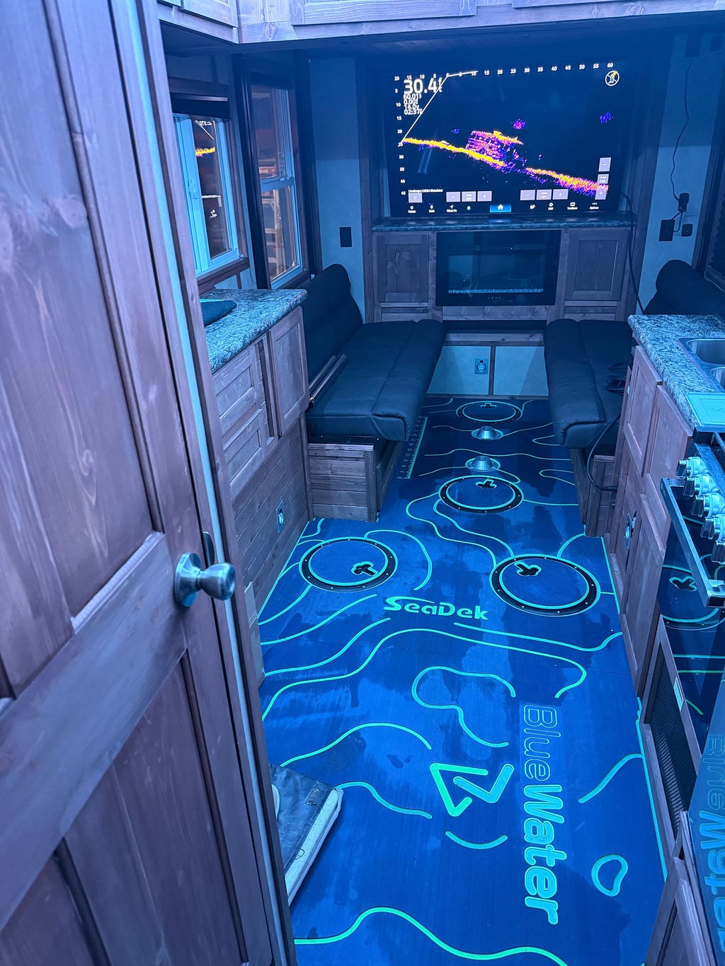 Wide doorway view of a BlueWater fish house electronics and SeaDek installation